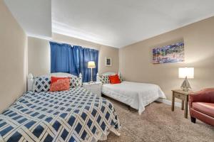 a bedroom with two beds and a chair and a couch at Destin on the Gulf 403 - This is a beautiful beach front condo with a great view of the gulf in Destin +13 photos