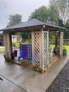 a wooden gazebo with a bunch of wine bottles at Room to rent in Mullingar