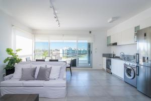 uma sala de estar com um sofá branco e uma cozinha em Your Oasis 2-BD Crystal Lagoon Pilar em Villa Rosa