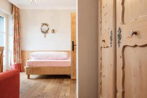 a bedroom with a bed and a door at Landhaus am Stein in Bad Wiessee