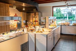 una cucina con bancone e cibo di Hotel La Pergola a Lignano Sabbiadoro