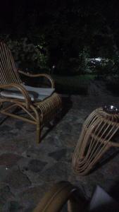 a wicker chair sitting on a stone patio at night at ROLEO Guest House in Lin