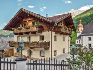 a house with wooden balconies and a fence at Falwesuna Apartments in Neustift im Stubaital
