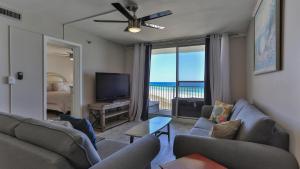 a living room with couches and a television and a balcony at Destin on the Gulf 604 - Updated Gulf Front sixth floor condo in Destin