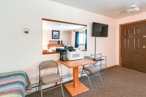 Cette chambre comprend une table avec des chaises et un four micro-ondes. dans l'établissement Cozy Cooper Landing Studio with Mountain Views!, à Cooper Landing