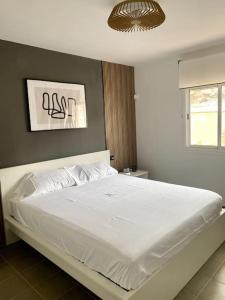 a bedroom with a large white bed in a room at Bonitos atardeceres sobre Los Cristianos in Chayofa