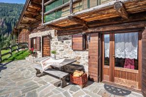 a patio with a picnic table and a building at Baita Valmesta in Fiera di Primiero