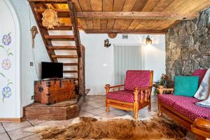 - un salon avec deux chaises et une télévision dans l'établissement Baita Valmesta, à Fiera di Primiero