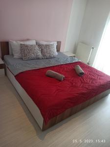 1 cama con 2 almohadas y manta roja en Apartman Best, en Doboj