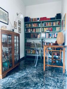 um quarto com uma mesa e uma estante de livros com livros em La casa di Dani em Florença