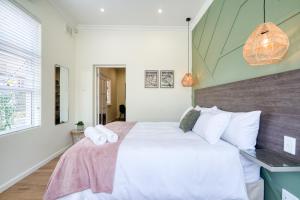 a bedroom with a large white bed with white pillows at Hampton Collection Modern 1 or 2 Bedroom Apartment with Pool in Durban