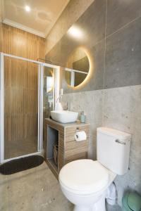a bathroom with a toilet and a sink and a shower at Hampton Collection Modern 1 or 2 Bedroom Apartment with Pool in Durban