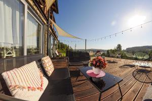 eine Terrasse mit einem Tisch und Stühlen sowie einer Vase aus Blumen in der Unterkunft Chata w Bieszczadzie widokowe apartamenty w Bieszczadach in Polańczyk