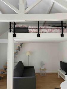 a living room with a couch and a loft bed at Proche Paris et Disney avec piscine-calme absolu, terrasse et parking privé in Vaires-sur-Marne