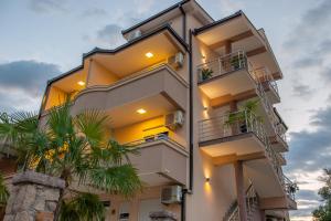 um edifício de apartamentos com varandas e palmeiras em M&M Apartments em Utjeha