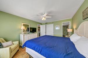 a bedroom with a blue bed and a couch at Destin on the Gulf 702 - Directly on the beach seventh floor with the best views in Destin