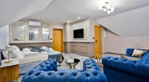 1 dormitorio con 1 cama y 2 sillas azules en Kompleks Gazdówka Apartamenty - Rabka Zdrój, en Ponice