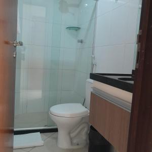 a white bathroom with a toilet and a shower at Akropolis Home in João Pessoa