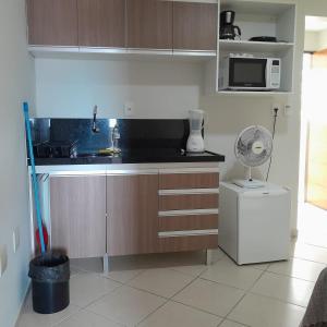 a kitchen with a sink and a microwave at Akropolis Home in João Pessoa