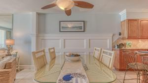 a dining room with a glass table and a ceiling fan at Destin on the Gulf 703 - Gulf Front Property 7th Floor in Destin