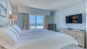a bedroom with a bed and a window with the ocean at Destin on the Gulf 703 - Gulf Front Property 7th Floor in Destin +13 photos