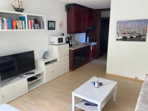 ein Wohnzimmer mit einem TV und einer Küche in der Unterkunft Amerigo Vespucci in Helgoland