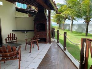 Un patio con chimenea y una mesa y sillas. en Casa no Paraíso dos Carneiros em Tamandaré, en Tamandaré