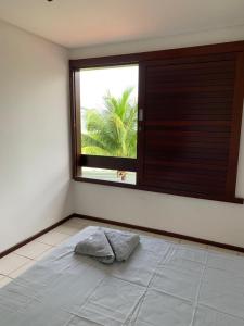 Habitación con ventana y almohada en el suelo en Casa no Paraíso dos Carneiros em Tamandaré, en Tamandaré