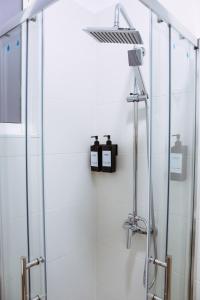 a shower in a bathroom with a glass shower stall at Triana Riverside Guesthouse in Seville