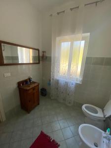 ein Badezimmer mit einem WC, einem Waschbecken und einem Spiegel in der Unterkunft Casa Franceschini in Poggio Mirteto