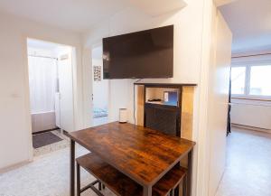 comedor con mesa de madera y TV de pantalla plana en Monteurunterkunft Heilbronn, en Heilbronn