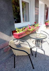 two chairs and a table in front of a window at Appartement Les Géraniums in Remiremont