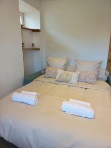 a large bed with two white towels on it at Appartement Les Géraniums in Remiremont