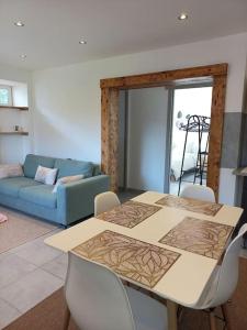 a living room with a table and a blue couch at Appartement Les Géraniums in Remiremont