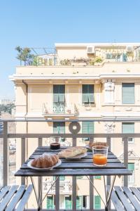 a table with two plates of food on a balcony at Decana Flexyrent Apartment in Genoa