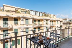 a table on a balcony with a building at Decana Flexyrent Apartment in Genova