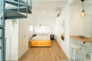 Un pequeño dormitorio con una cama y una escalera en Casa La Fontana 1 en Vejer de la Frontera
