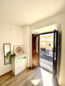 un pasillo con una puerta que conduce a un balcón en Triana Riverside Guesthouse, en Sevilla