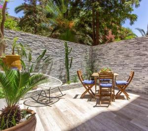 a patio with a table and chairs and a brick wall at Luxury Duplex - Private Jacuzzi - Center Hivernage in Marrakech