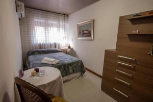 a bedroom with a bed and a table and a dresser at Exclusivo Apto Calle Principal in Salto