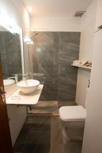 a bathroom with a sink and a toilet and a mirror at Exclusivo Apto Calle Principal in Salto