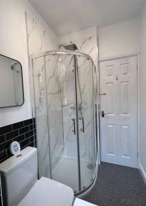 a bathroom with a glass shower with a toilet at Entire Spacious Bungalow Retreat in Bromsgrove