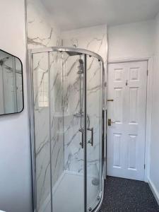 a shower with a glass door in a bathroom at Entire Spacious Bungalow Retreat in Bromsgrove