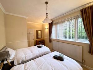 a room with two beds and a window at Entire Spacious Bungalow Retreat in Bromsgrove
