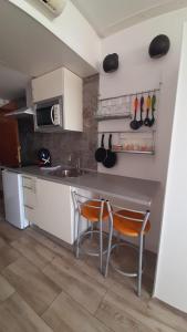 a kitchen with a table and two chairs and a sink at GLP RISCAL 2 in Alicante