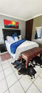 um quarto com uma cama grande e um banco em Mthandi Wokuhamba Lodge em Dundee