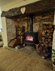 a brick fireplace with a stove in a room at Jackdaw Cottage-Beautiful Cottage, Town Centre in Wimborne Minster