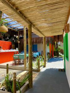 a wooden pergola with tables and a restaurant at Pousada Crocodilo Caraíva in Caraíva