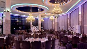 a banquet hall with tables and chairs and chandeliers at Zura palace in Kvariat'i
