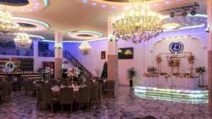 a banquet hall with tables and chairs and chandeliers at Zura palace in Kvariat'i